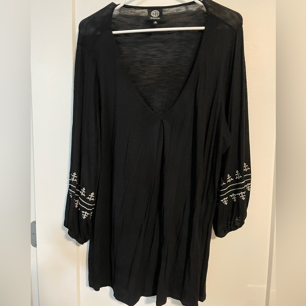 Black V-neck with white embroidery around sleeves